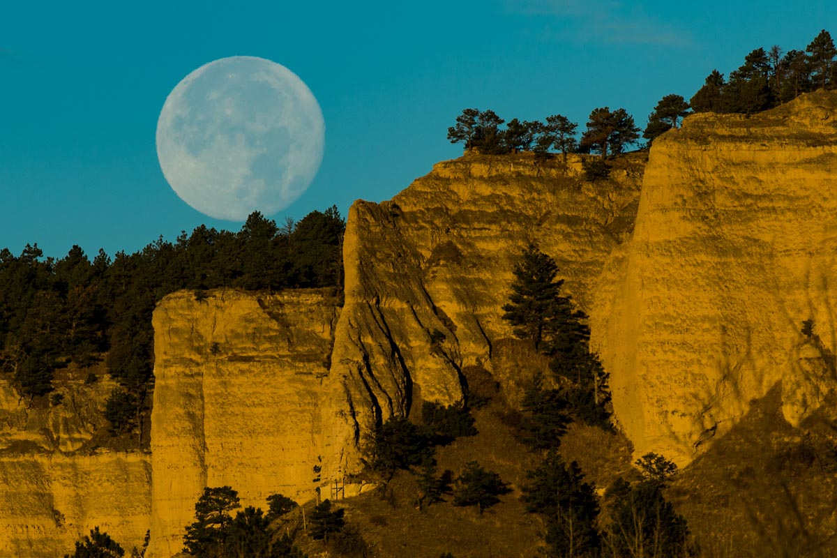  A supermoon hangs above the pine-studded Red Cloud Buttes at Fort Robinson State Park near Crawford. Photo by Justin Haag.